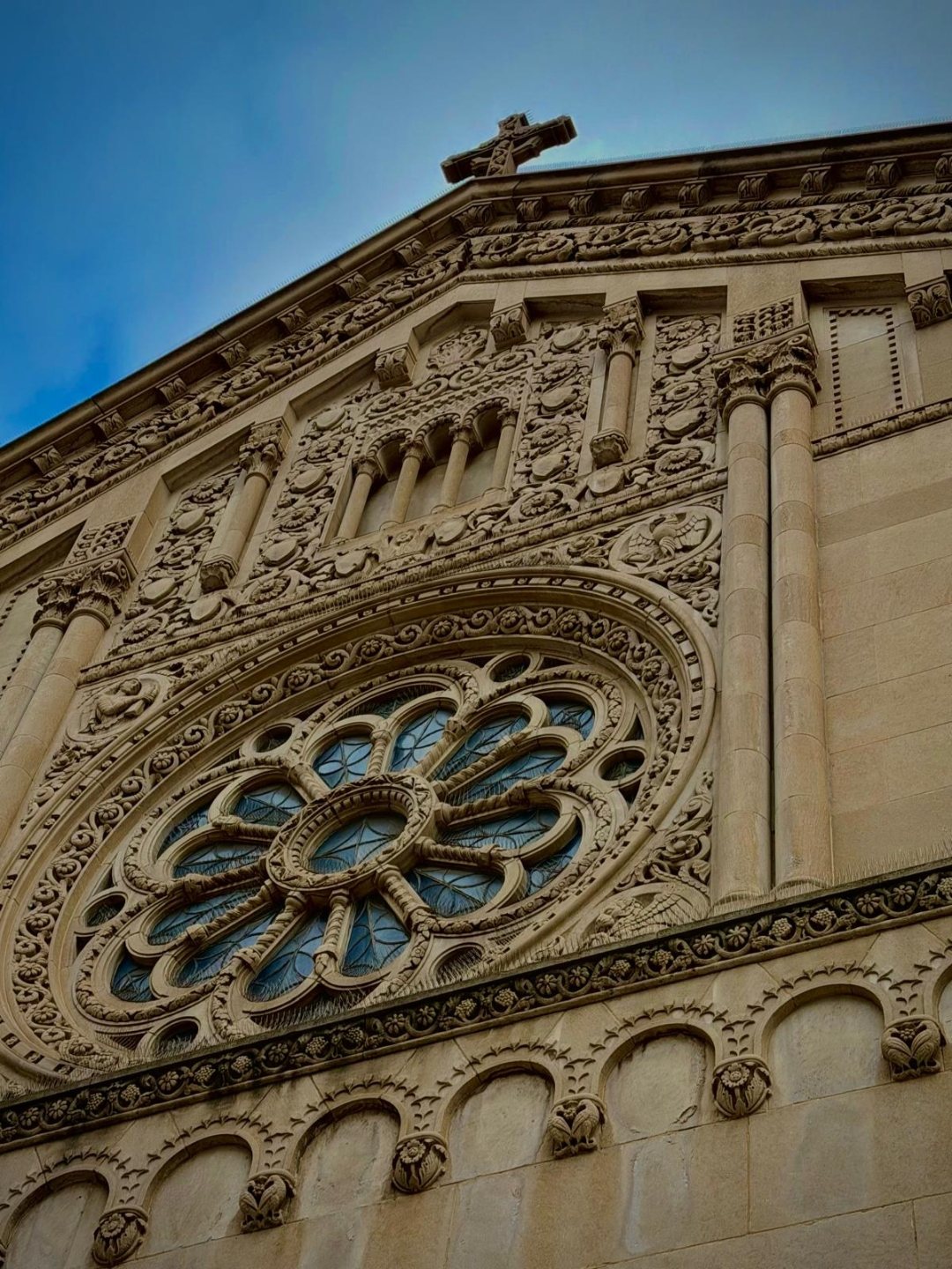 Ornate stone facade of a Detroit cathedral with a large rose window